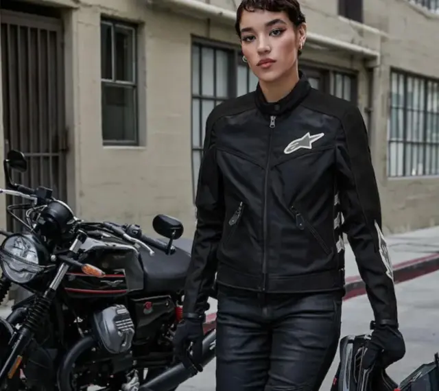 Donna con giacca e jeans da moto, pronta per partire. L'abbigliamento obbligatorio moto garantisce sicurezza e stile.
