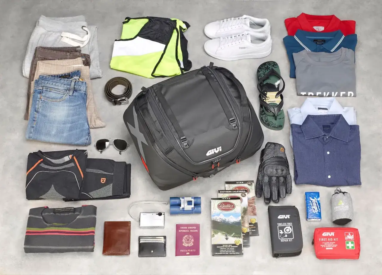 Tutto l'occorrente per un avventuroso campeggio in moto: abbigliamento, zaino Givi, guanti, mappe e kit di pronto soccorso.