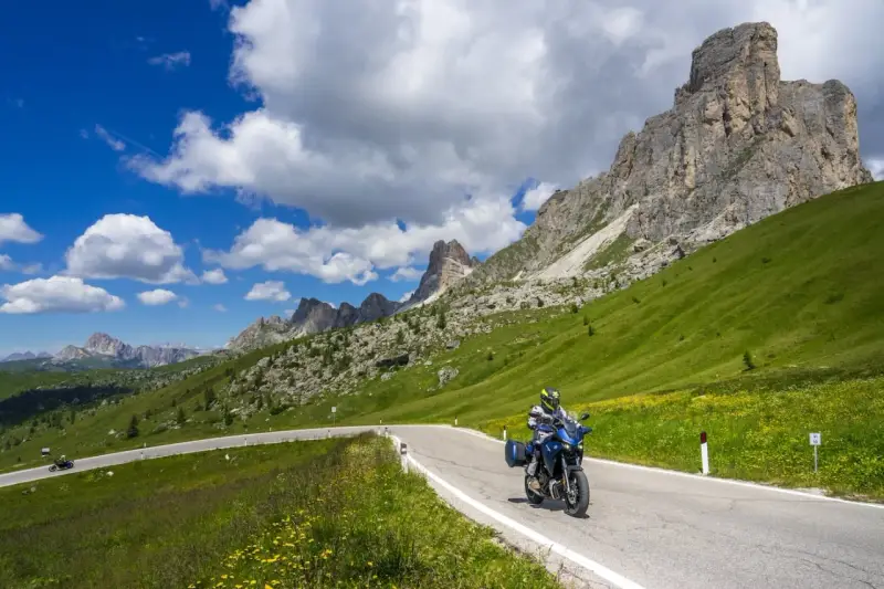 Motociclista su strada panoramica tra le montagne, un invito a scoprire le **strade da fare in moto** con panorami mozzafiato.